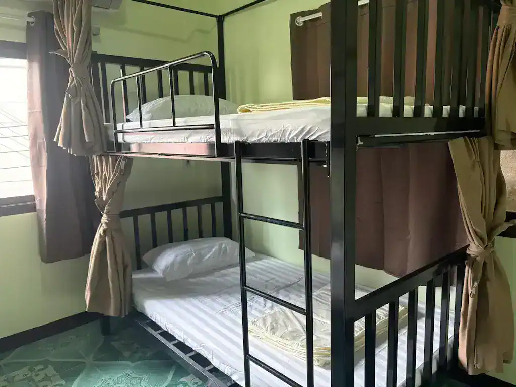 Dorm bunk beds with privacy curtains at Apple House Koh Tao